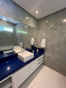 ein Badezimmer mit Waschbecken und Spiegel in der Unterkunft Casa Toquinho Ipojuca-PE in Ipojuca