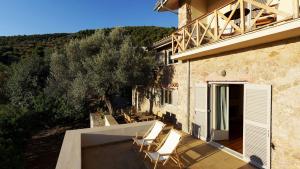 un balcón de una casa con sillas. en Epidaurus Olive Villa, en Nea Epidavros