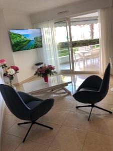 a living room with two chairs and a television at T2 & Garage FRONT DE MER résidence de Standing in Fréjus