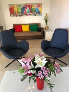 two chairs and flowers on a table in a living room at T2 & Garage FRONT DE MER résidence de Standing in Fréjus