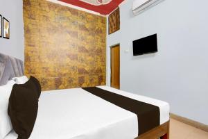 a bedroom with a bed and a tv on a wall at Hotel O HERITAGE HOTEL in Hardoī