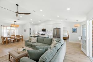 a living room and kitchen with a couch and a table at Sunny 3BR with Hot Tub & Game Room Home in Gulf Breeze