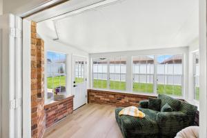 a living room with a couch and windows at Sunny 3BR with Hot Tub & Game Room Home in Gulf Breeze +23 photos