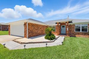 a brick house with a white garage at Sunny 3BR with Hot Tub & Game Room Home in Gulf Breeze