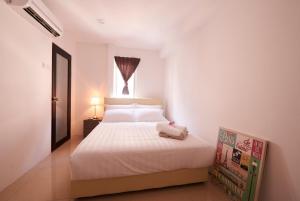 a bedroom with a white bed and a window at Ipoh Road Hotel in Kuala Lumpur