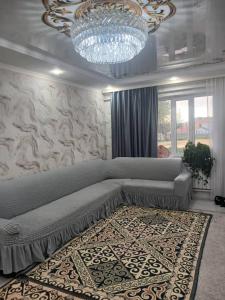 a bedroom with a large bed and a chandelier at Bakvt Homestay & Breakfast & Horse Riding Tours in Dzhangyaryk