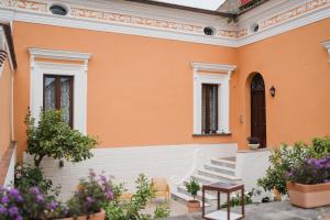 ein orangefarbenes Haus mit Treppen und Blumen in der Unterkunft La Residenza del Barone in Camerota