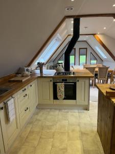 a kitchen with a stove top oven in an attic at The Retreat in Frettenham +8 photos
