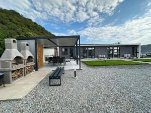 a modern house with a bench on a gravel patio at Casa WEEK Dunare in Baziaş