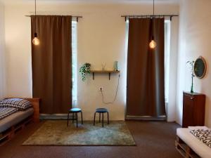 a room with two stools and a bed and two windows at Green Park Rooms Brno in Brno