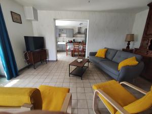 a living room with a couch and a tv at Gîte L'épinette in Grozon