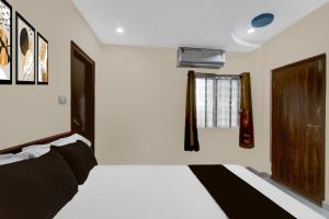 a bedroom with a bed and a window at Hotel O SR Grand in Bībīnagar +21 photos