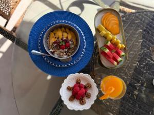 a table with a bowl of cereal and a tray of fruit at Aurora Boutique - Only Adults in Marbella