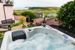 a bath tub with a view of the ocean at Priory Bay Escapes - Uminari in Tenby