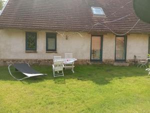a house with a table and chairs in the yard at Ferienhaus Lehmhaus in Häven