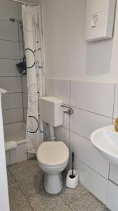 ein weißes Badezimmer mit Toilette und Waschbecken in der Unterkunft Green Apartment Studio L30 Neukölln in Berlin