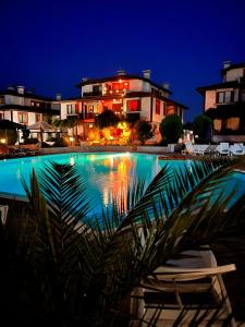 a swimming pool at night with chairs and buildings at Velika Garden Villas 1 bedroom apartment, Lozenets in Lozenets