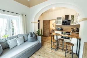 a living room with a couch and a kitchen at Ferienbahnhof Fichtental Bahnhofs-Apartment in Prackenbach