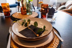 a plate with leaves on it sitting on a table at Priory Bay Escapes - Uminari in Tenby
