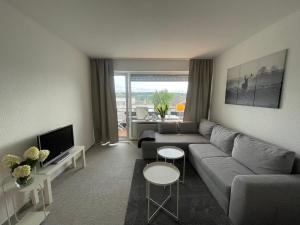 a living room with a couch and a tv at Ferienapartment Zeit am See in Körbecke