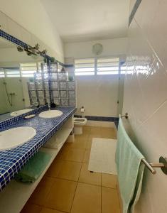 a bathroom with two sinks and a toilet at Villa Amaryllis in Le Gosier