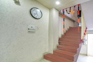 a clock on a wall next to a staircase at SPOT ON Hotal Krishna in Dīp