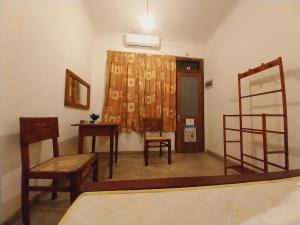 um quarto com uma mesa e cadeiras e um espelho em Waves em Hikkaduwa