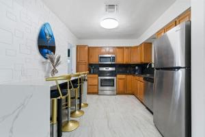 a kitchen with stainless steel appliances and wooden cabinets at 4BR Hollywood Villa 3 min to Beach, Heated 12-Person Jacuzzi, Game Room and BBQ in Hollywood