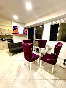 a living room with purple chairs and a glass table at Urbanización Florida Norteamérica in Bello