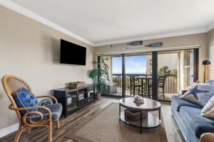 a living room with a blue couch and a table at Amelia Surf and Racquet Club Condo - 3rd Floor - Ocean View - Pools - Tennis Courts - Sleeps 8 in Fernandina Beach