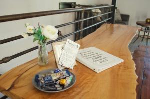 a table with a vase of flowers and a book at PNW Scenic Loft with Kitchenette in Philomath
