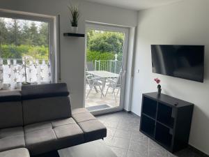 a living room with a couch and a television and a table at Eastside - Apartment WHG 02 in Senftenberg