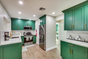 a kitchen with green cabinets and a refrigerator at Backyard Oasis Fort Lauderdale Home Near Beach in Fort Lauderdale