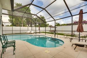 a swimming pool with a glassconservatory with a chair at Backyard Oasis Fort Lauderdale Home Near Beach in Fort Lauderdale