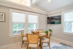 サウス・ヤーマスにあるWalk to Beaches Pet-Friendly Cape Cod Home!のテーブルと椅子と窓のあるダイニングルーム