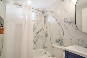 サウス・ヤーマスにあるWalk to Beaches Pet-Friendly Cape Cod Home!の白いシャワーカーテンと洗面台のあるバスルーム +21枚の写真