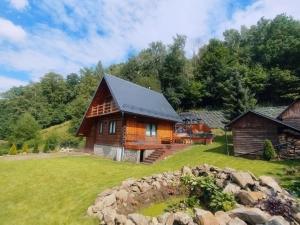 una casa di tronchi su un campo erboso con alberi di Lawendowe wzgórze a Pieszyce