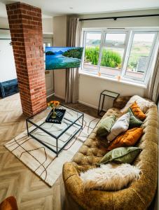 una sala de estar con un sofá y una mesa en Priory Bay Escapes - Uminari, en Tenby