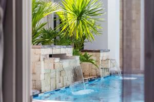 a swimming pool with a waterfall in a resort at Winds Boutique Hotel in Angeles