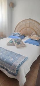 a large bed with blue and white sheets and pillows at Résidence la Citadelle in Saint-Florent