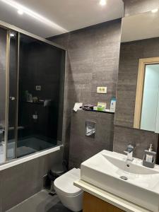 a bathroom with a sink and a toilet and a shower at Venus Luxury Apartment in Skopje