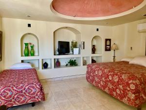 a bedroom with two beds and a flat screen tv at Hospedaje Mulege in Puerto Peñasco