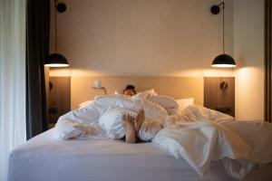 a man laying in bed under the sheets at ELVA PREMIUM APARTMENT HOTEL inklusive Sommerpass STUBAI SUPER CARD in Neustift im Stubaital