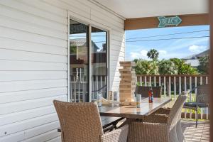 un patio con tavolo e sedie su un portico di 6 Bedrooms 4 Bath with sand and heated pool a Clearwater Beach