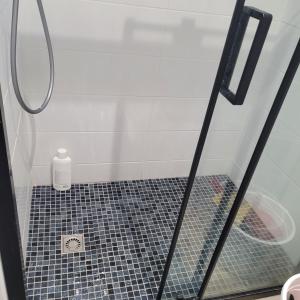 a shower with a glass door with a bottle on the floor at Maison pour 4 personnes à 2 pas de Paris superficie 40m2 in Bondy