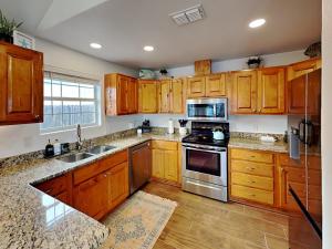 a kitchen with wooden cabinets and stainless steel appliances at Inn at Dolphin Bay in Rockport +23 photos