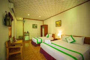 ein Hotelzimmer mit zwei Betten und einem Fernseher in der Unterkunft Bamboo Resort Phu Quoc in Phu Quoc
