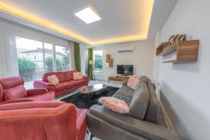 a living room with a couch and chairs and a tv at Doğa apart in Kas