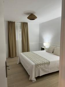 a bedroom with a white bed and a window at Casa Vella de Casa Torrent in Canet de Mar +34 photos