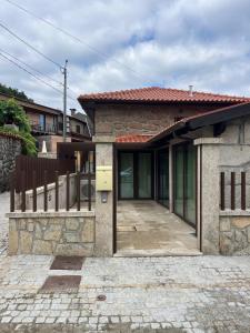 una casa di mattoni con una recinzione di fronte di Cantinho da Cuca - Gerês a Terras de Bouro